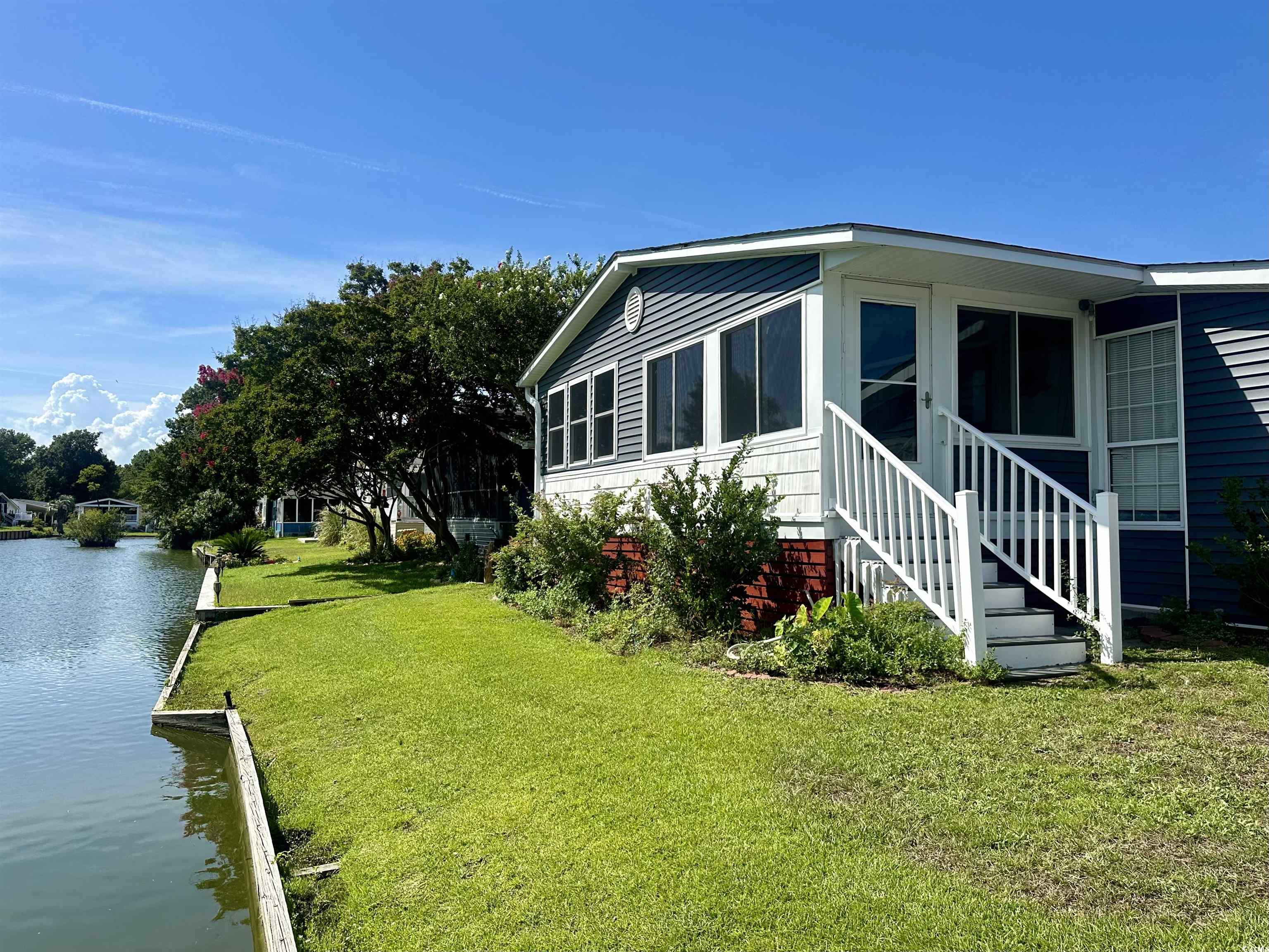 View of side of property with a water view and a l