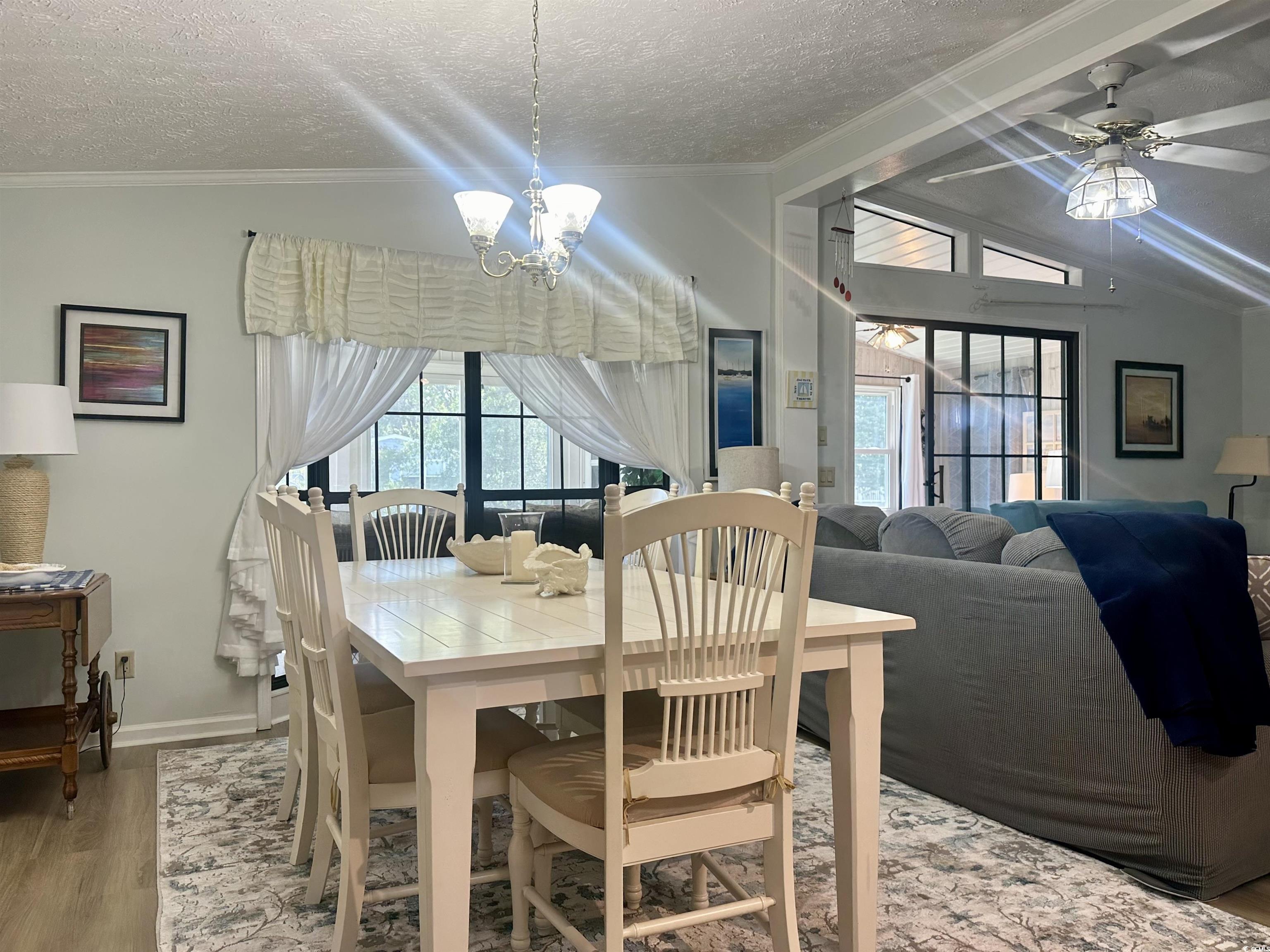 Dining room featuring vaulted ceiling, a textured