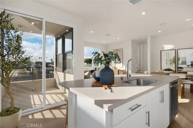 a kitchen with stainless steel appliances granite countertop a stove a sink a microwave a refrigerator and white cabinets