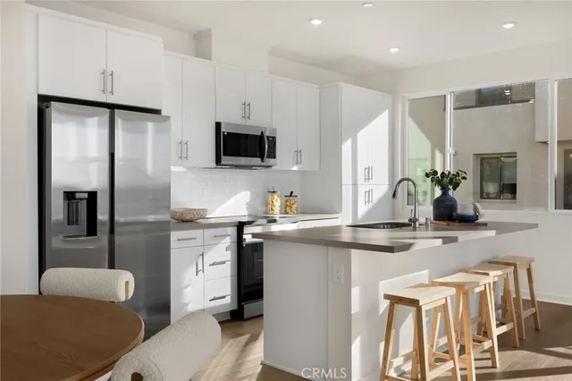 a kitchen with a sink a refrigerator and cabinets
