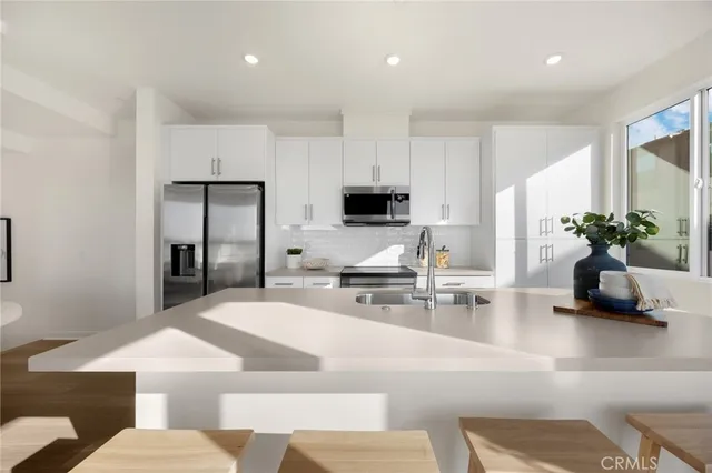 a kitchen with stainless steel appliances granite countertop a sink a stove and a refrigerator