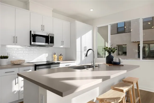 a kitchen with stainless steel appliances a dining table and chairs