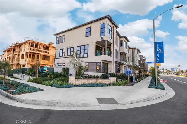 a view of a blue and white house with lawn chairs in front of it