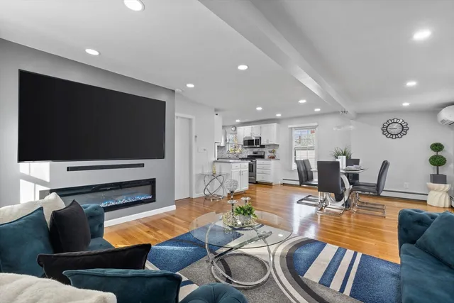 a living room with furniture kitchen view and a flat screen tv
