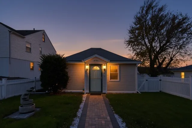 a front view of a house with a yard and a garden