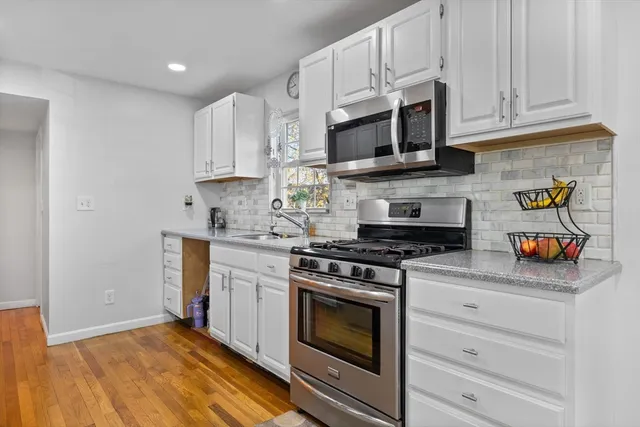 a kitchen with stainless steel appliances granite countertop a stove and a microwave