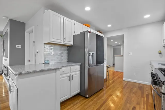 a kitchen with stainless steel appliances granite countertop a refrigerator and a sink