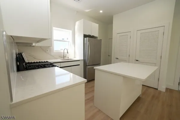 a kitchen with a refrigerator and a stove top oven