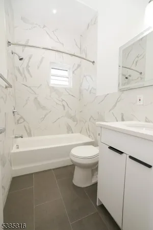 a bathroom with a toilet sink vanity tub and shower