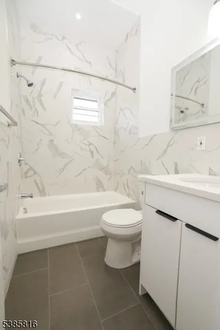 a bathroom with a toilet sink vanity tub and shower