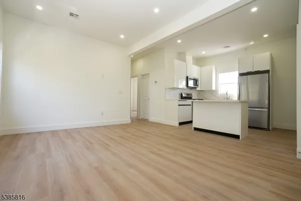 a view of a kitchen with a sink and wooden floor