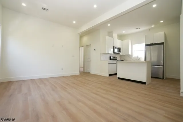 a view of a kitchen with a sink and wooden floor