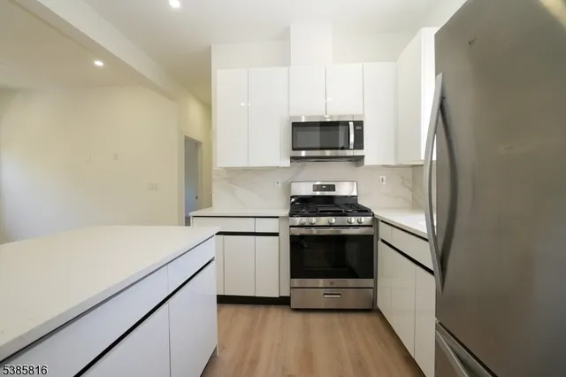 a kitchen with stainless steel appliances a sink a stove a microwave and cabinetry