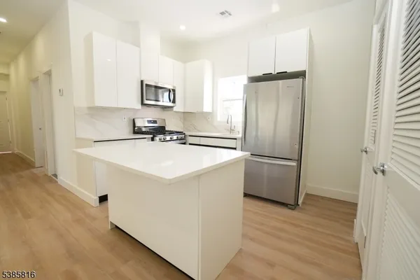 a kitchen with a sink refrigerator and microwave