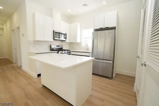 a kitchen with a sink refrigerator and microwave