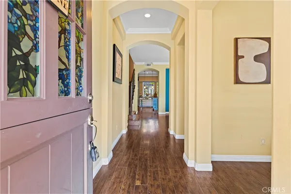 a view of a hallway with wooden floor and entryway