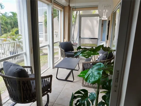 a balcony with chairs and a potted plant