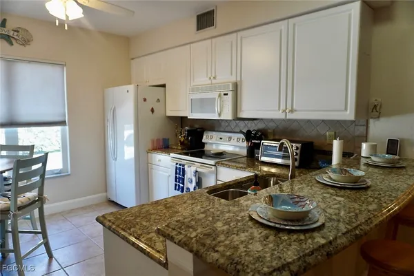 a kitchen with stainless steel appliances granite countertop a sink a stove and a refrigerator