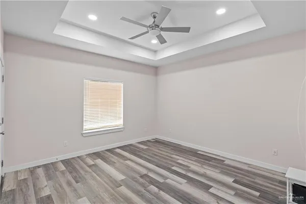 an empty room with a window and a ceiling fan