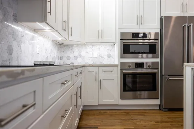 a kitchen with stainless steel appliances white cabinets and a granite counter tops