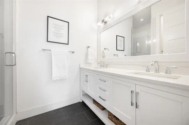 a bathroom with a double vanity sink a mirror and a shower