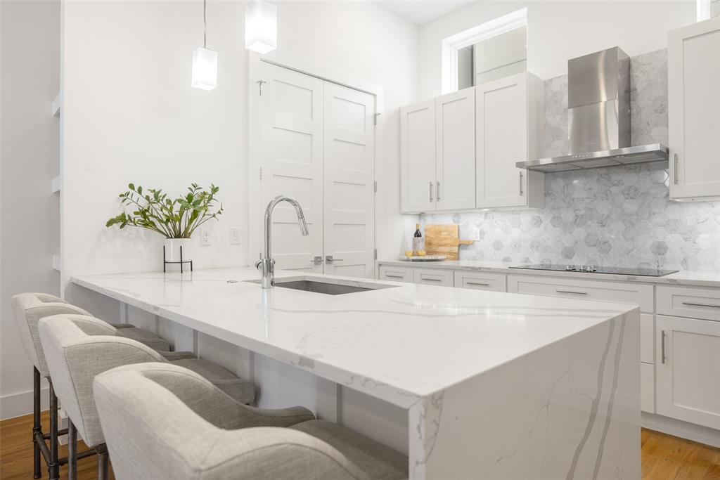 1727 Caddo Street, Unit 103 Dallas, TX 75204 - Photo 2 of 27 a kitchen with stainless steel appliances a sink a stove and white cabinets