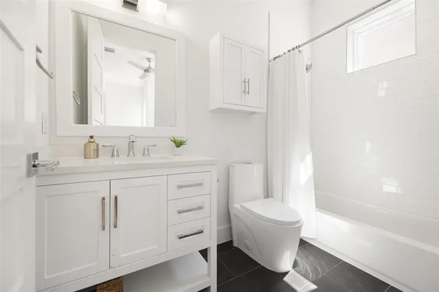 a bathroom with a sink toilet vanity and tub