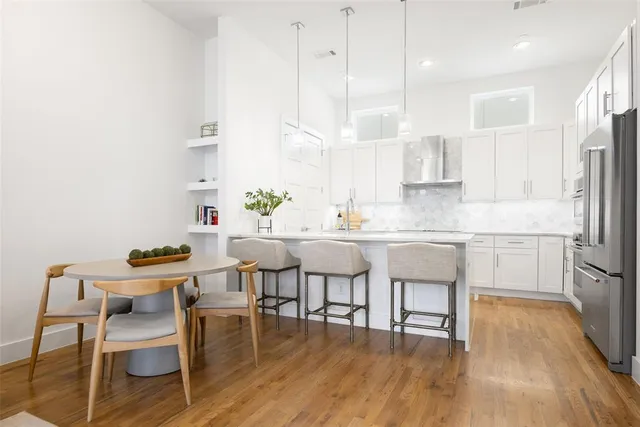 a kitchen with stainless steel appliances granite countertop a dining table chairs stove a sink and dishwasher