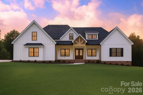 a front view of a house with a garden and yard