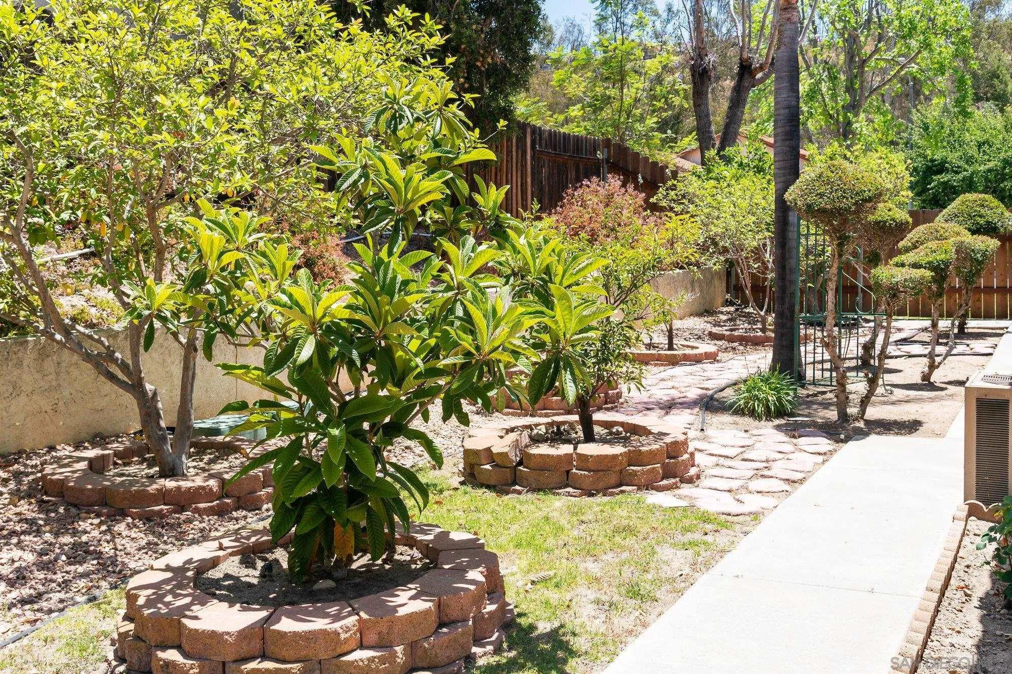 13926 Carriage Road Poway, CA 92064 - Photo 35 of 54 a backyard of a house with table and chairs under an umbrella