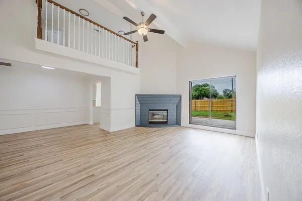 a view of an empty room with a fireplace and a window