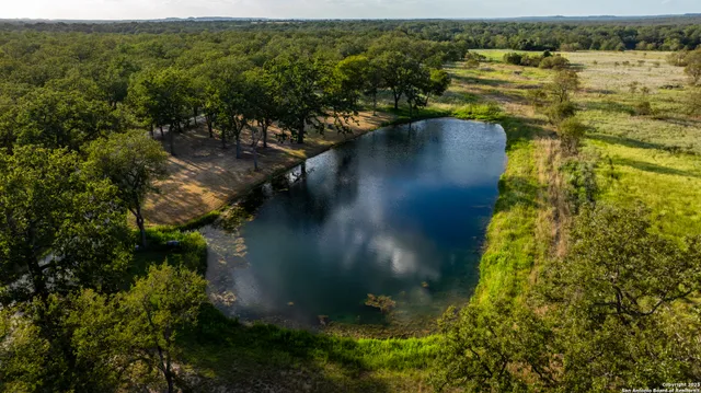 an aerial view of residential houses with outdoor space and trees