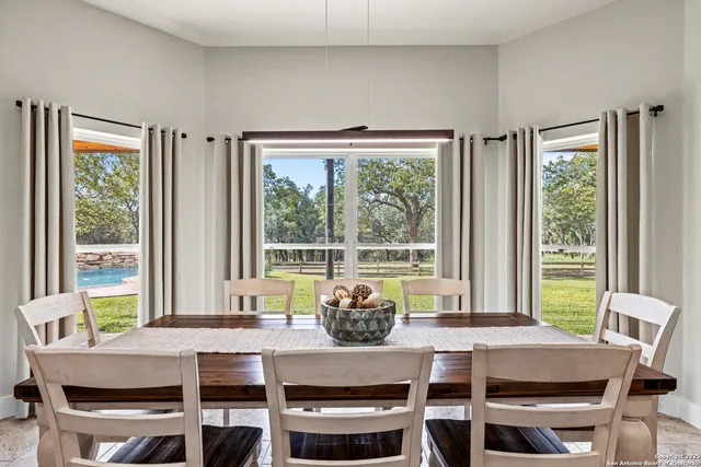 a dining room with furniture a large window and a table