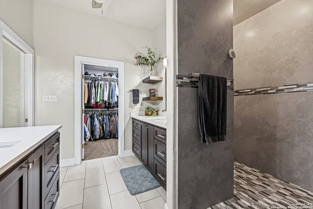 a walk in closet with wooden floor