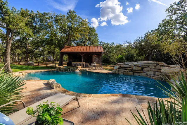 a view of a swimming pool with lounge chairs in patio