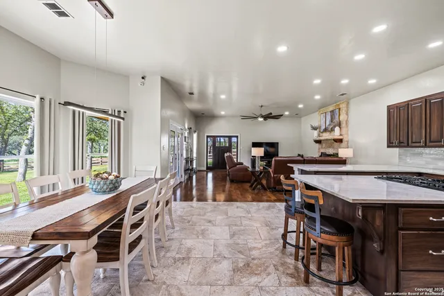 a group of people sitting in a room with kitchen view