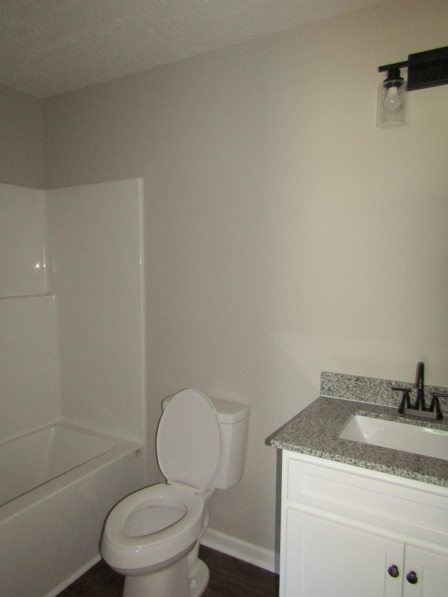 470 Crescent Factory Road Lawrenceburg, TN 38464 - Photo 11 of 15 a bathroom with a granite countertop toilet a sink and bathtub