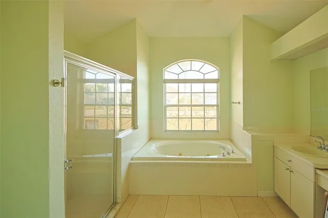 a spacious bathroom with a granite countertop tub sink a mirror and a bathtub