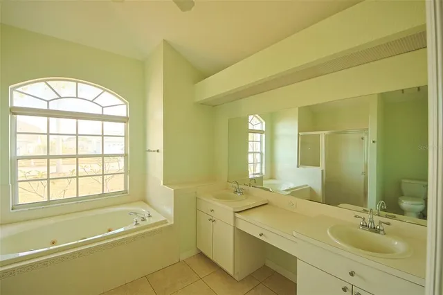 a bathroom with a granite countertop bathtub shower and a toilet
