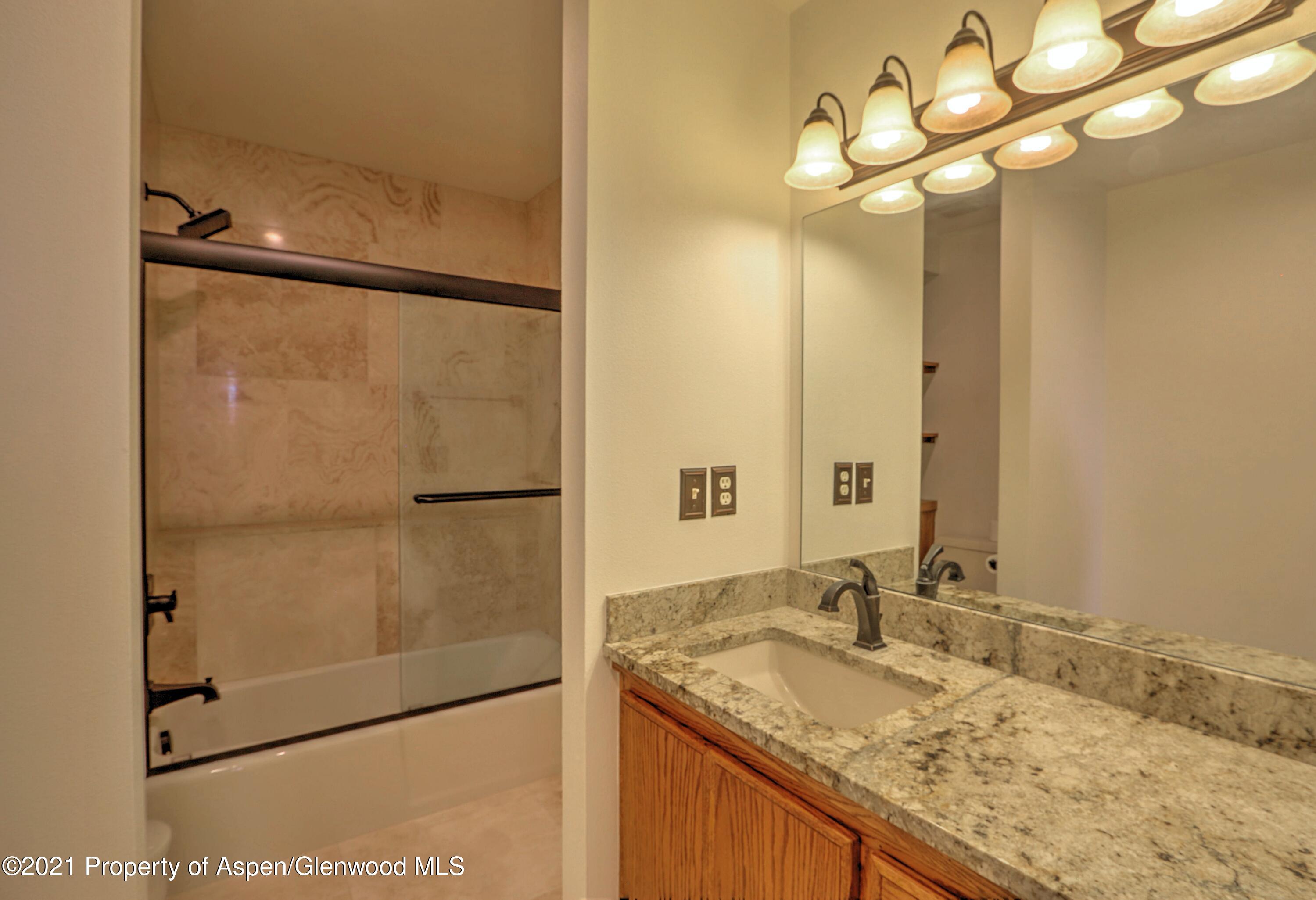 534 Panoramic Drive Silt, CO 81652 - Photo 33 of 48 a bathroom with a granite countertop sink a mirror and a shower