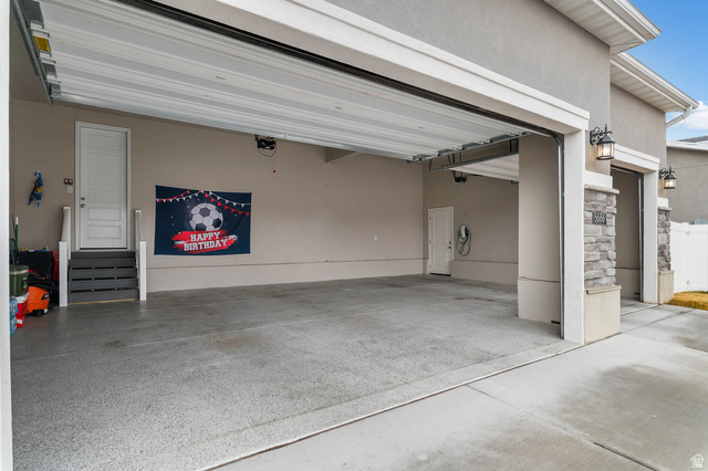 5686 Duke Lane Tooele, UT 84074 - Photo 10 of 38 Garage featuring concrete driveway and car charger