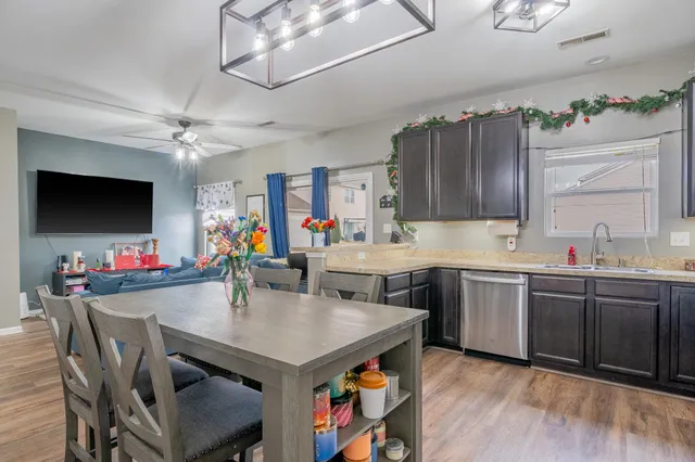 a kitchen with a table chairs sink and cabinets
