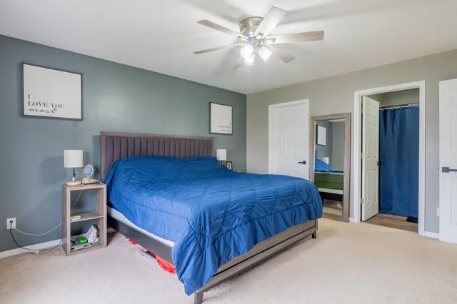 a bedroom with a large bed and a chandelier