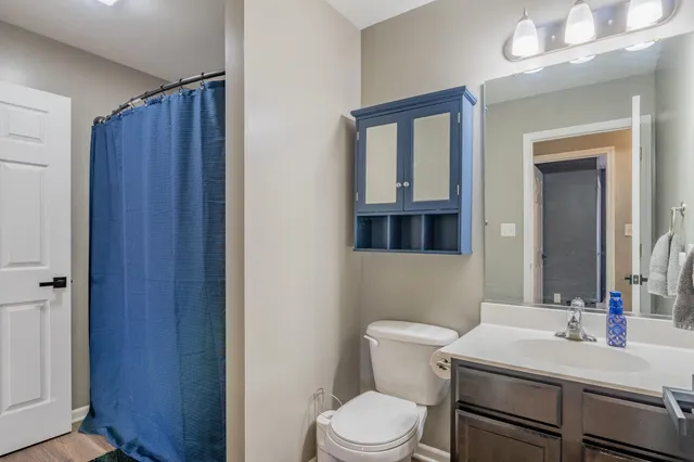 a bathroom with a toilet a sink and mirror