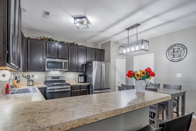 a kitchen with stainless steel appliances kitchen island granite countertop a stove refrigerator and microwave
