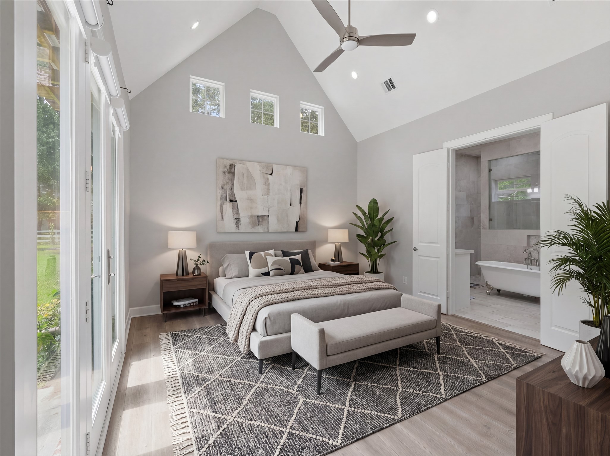 7106 Hampton Court Spring, TX 77389 - Photo 4 of 31 Spacious master bedroom with high ceilings, natural light, and modern decor. Features an en-suite bathroom with a freestanding tub. French doors lead to a garden view, enhancing the airy atmosphere. (virtually staged)