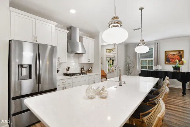 a kitchen with stainless steel appliances a dining table chairs and kitchen view