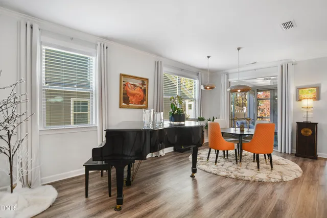 a living room with furniture a large window and wooden floor