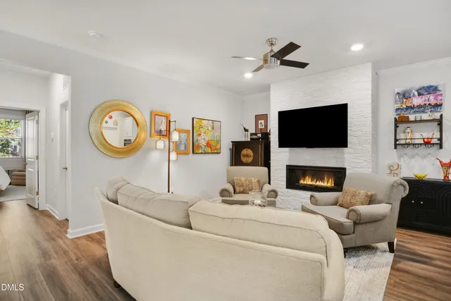 a living room with furniture a fireplace and a flat screen tv