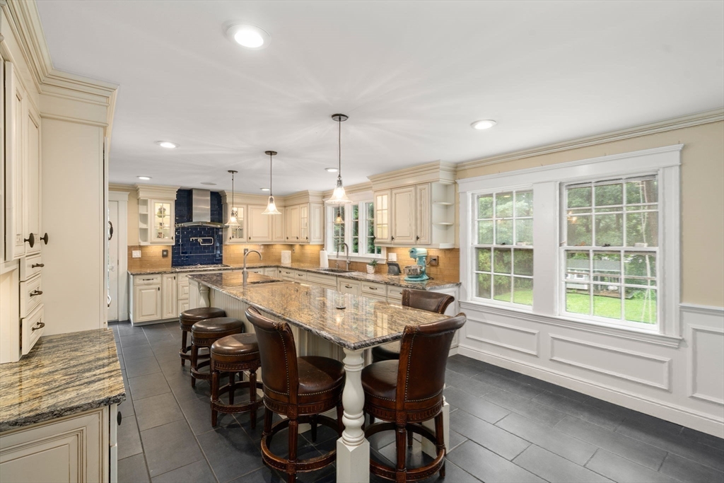 14 Sunset Road Wellesley, MA 02482 - Photo 13 of 39 a dining hall with stainless steel appliances kitchen island granite countertop a table chairs and a refrigerator